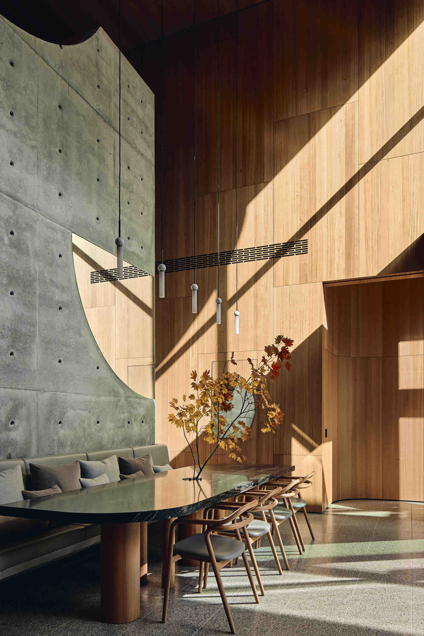 A modern double-height dining area with built-in banquette seating.
